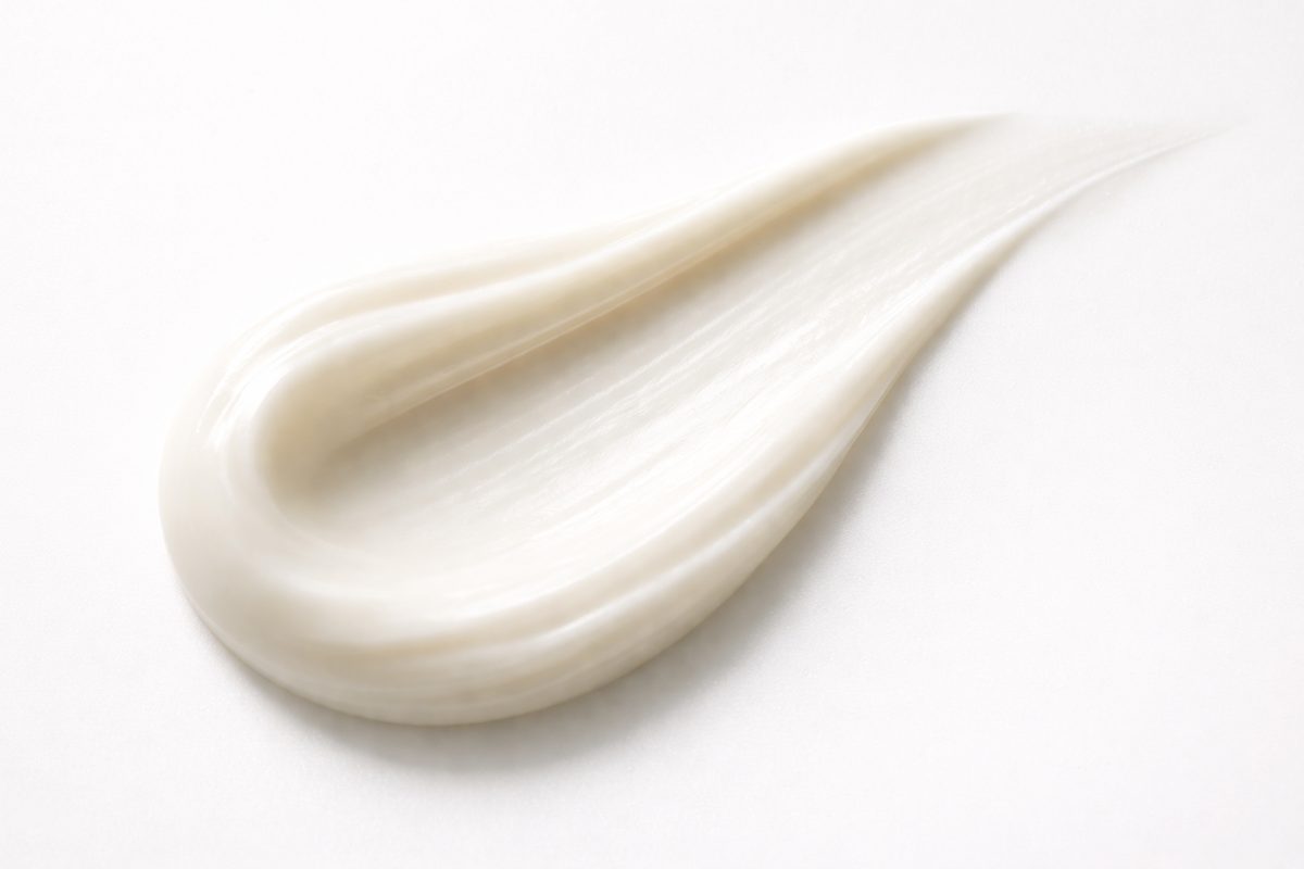 Macro view of a smooth, luxurious cream texture on a white background.